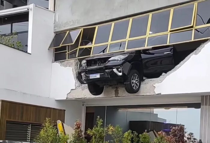 Carro atravessa parede e fica pendurado em garagem de prédio de Balneário Camboriú
