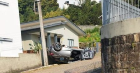 Carro capota em garagem em Rio do Sul após condutora esquecer de puxar o freio de mão