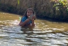 Menina encanta ao pescar peixe com as próprias mãos em rio de Minas Gerais