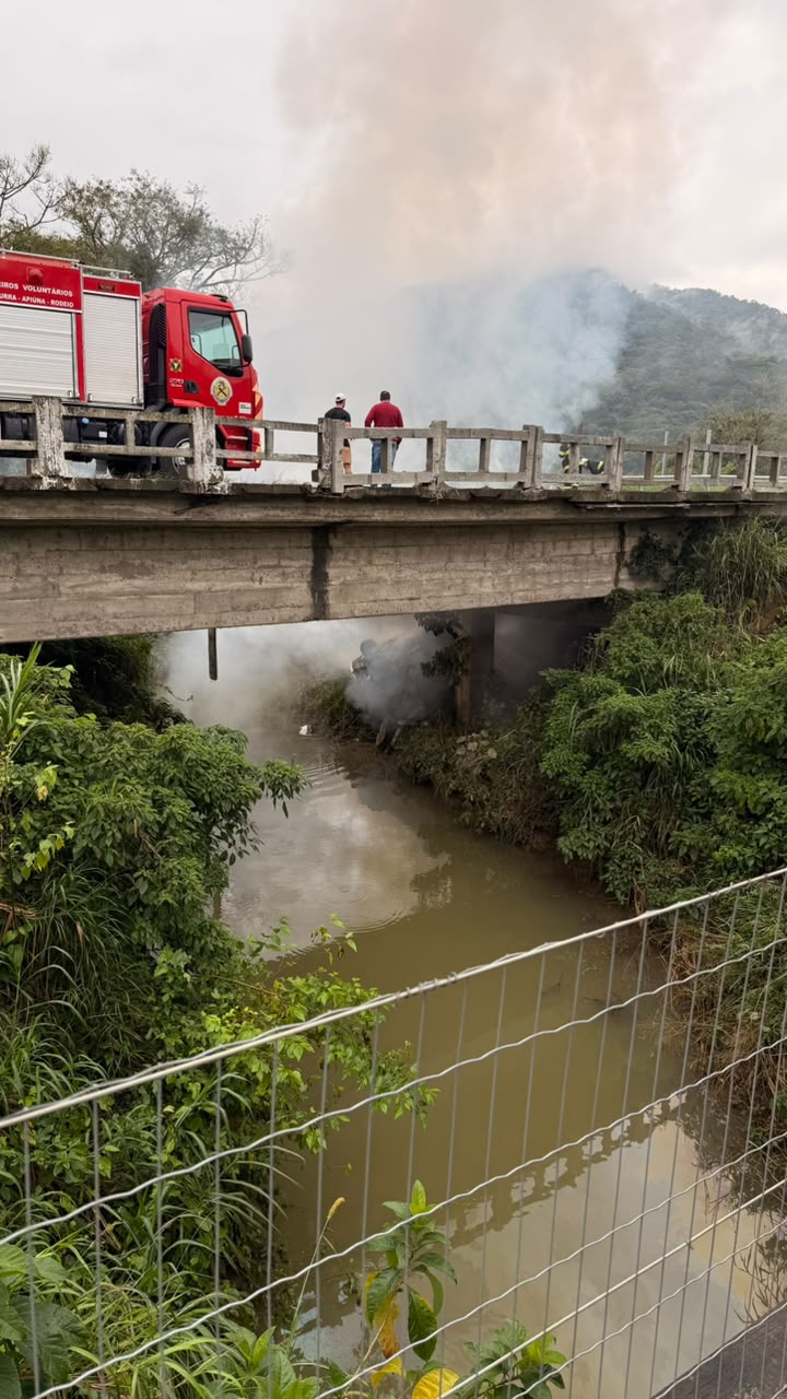 Carro sai da pista, cai em ponte e é completamente destruído pelo fogo na BR-470, em Rodeio
